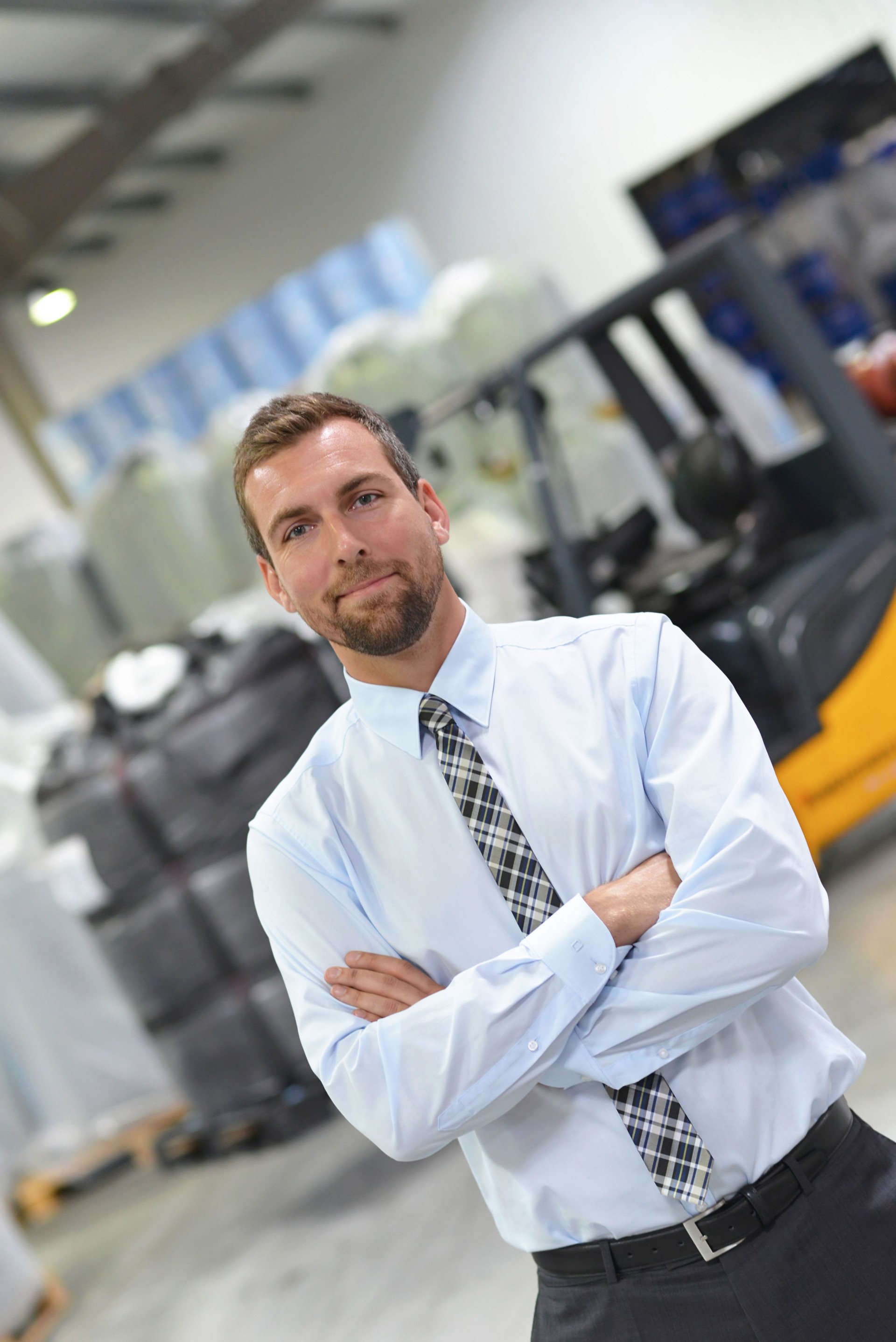 portrait of a manager in a logistics company - in the background a warehouse with chemicals and goods of a chemical factory